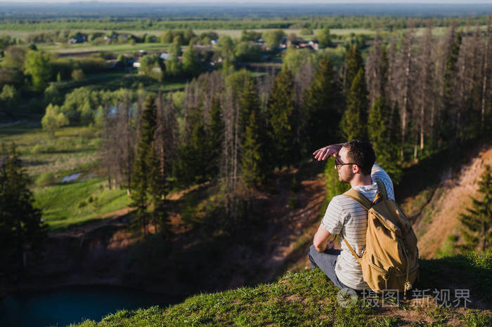 一个人在大自然的背景与背包在他的背上人看远处