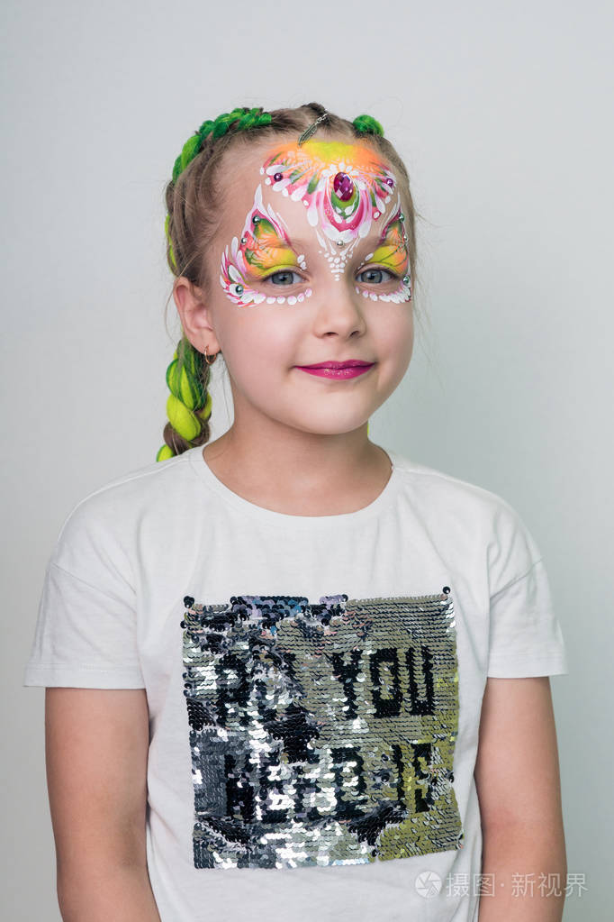 美丽的小女孩与画的脸与鲜花面部彩绘