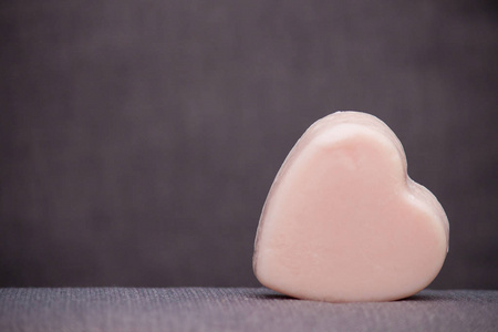 粉红色的心从肥皂或蜡烛在棕色灰色背景。情人节快乐。复制空间。