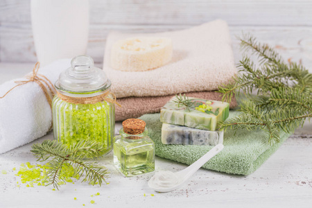 天然化妆油海盐面膜和天然手工皂与针叶提取物在白色乡村木制背景。 健康的皮肤面部和身体护理。 水疗和桑拿的概念。