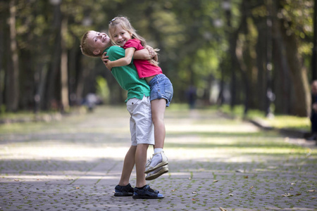 两个可爱的,年轻的,有趣的,微笑的孩子,女孩和男孩哥哥抱着妹妹在模糊