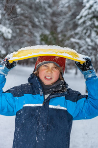 冬天一个男孩的特写肖像用雪碟盖住了他的头