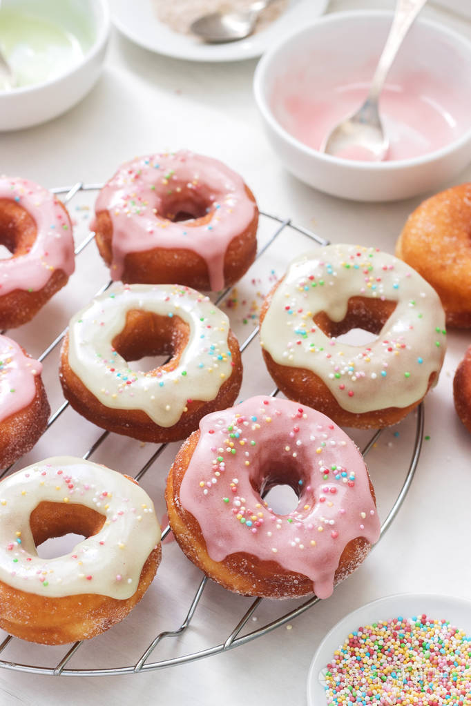 自制甜甜圈装饰彩色糖霜和彩色糖在一个轻的背景选择性聚焦