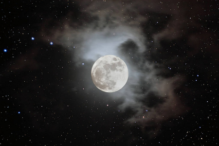 一朵云美丽的满月在繁星的夜晚看到一朵云覆盖着月亮.照片