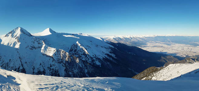 从皮林山顶到山脊峰的全景。 寒冷的雪冬天和晴朗的蓝天。