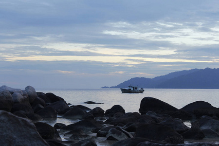 海滨黎明的景色，有戏剧性的天空船和山地提曼岛