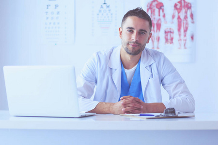 男性医生的肖像坐在办公桌在医疗