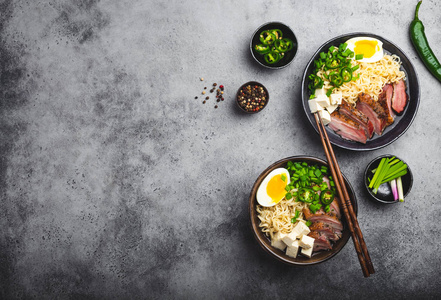 美味的亚洲面条汤拉面与肉汤豆腐猪肉蛋在灰色的乡村混凝土背景空间