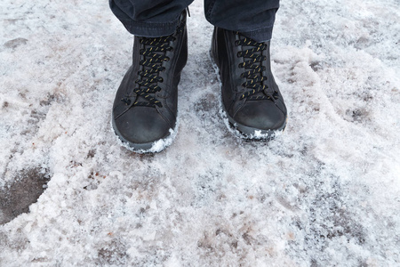 穿靴子的雄脚站在纯洁的冬雪里