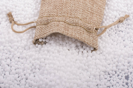 白色聚苯乙烯泡沫球作为背景的小袋子