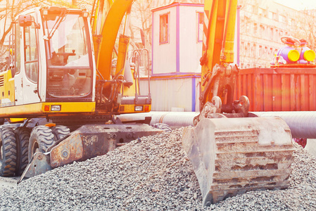 城市公用工程和道路工程修复过程中卸碎石用轮式装载机挖掘机作业..住房和社区服务。工业建筑工地的详细资料