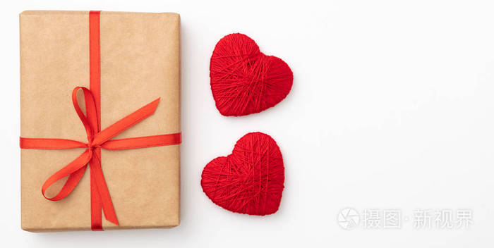 情人节装饰与工艺纸礼品盒与红色丝带和小红心查出在白色背景。顶部视图。爱天概念平放置