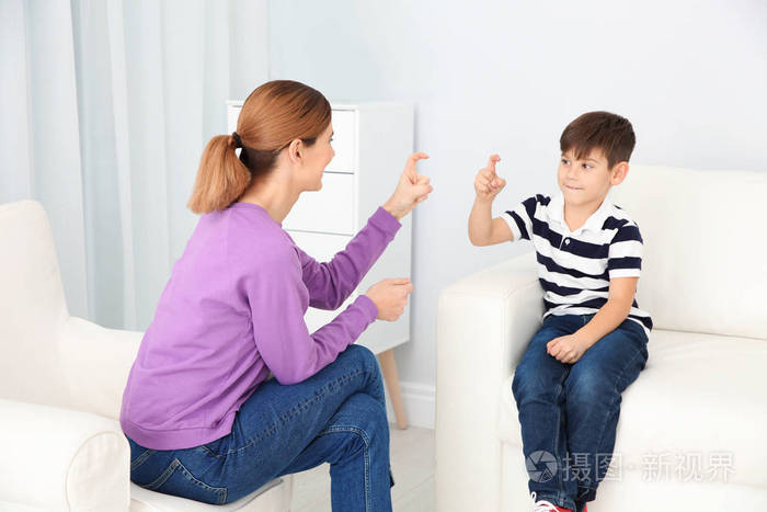 听力受损的母亲和她的孩子在室内用手语说话