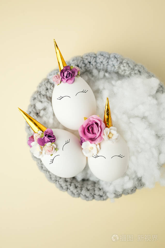 复活节假期概念与可爱的手工鸡蛋,独角兽,花装饰鸟巢.
