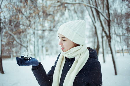 举行高加索年轻美丽的高加索女孩在雪的背景下, 冬季公园举行雪花照片