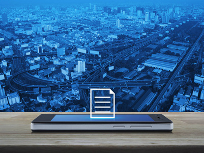 现代智能手机屏幕平面图标在木桌上，城楼街道高速公路和摩天大楼商务通信在线概念