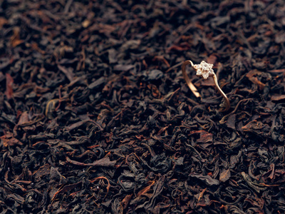 红茶叶的背景。 珍贵的戒指。 装饰品