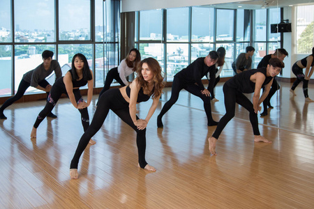 一群亚洲人在灯光工作室的训练中表演漂亮的当代舞蹈