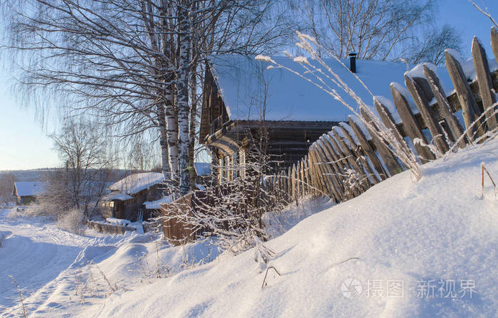 冬天的乡村景观白雪覆盖着被太阳照亮的村庄房屋.