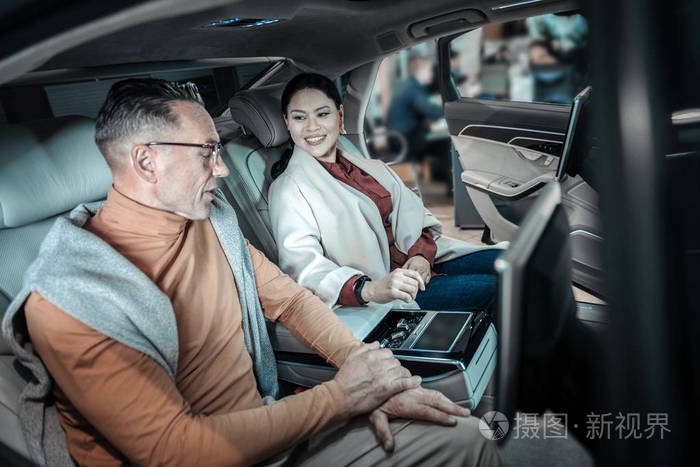 丈夫和妻子在选择汽车时坐在后座上