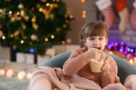 可爱的小女孩在圣诞前夜在家喝热巧克力和吃饼干
