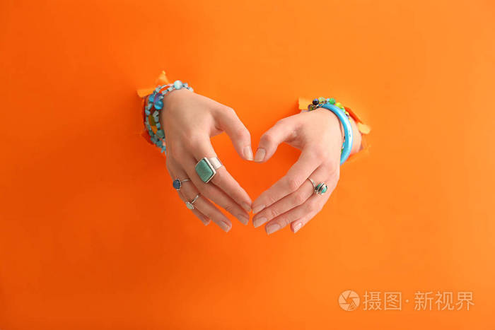 双手漂亮的年轻女人与时尚的双手在颜色背景上照片-正版商用图片17a9