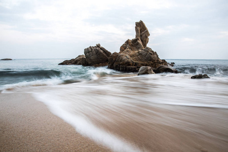 蓝色波浪海中坚硬岩石的风景