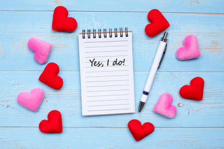 我爱你的文字笔记，书和笔与红色和粉红色的心形装饰在蓝色木桌背景。 爱情婚礼浪漫快乐情人节假期概念