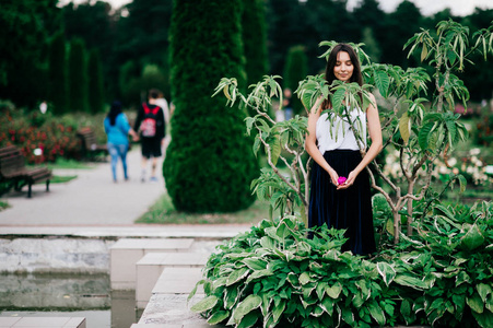 在植物园摆姿势的年轻黑发女孩