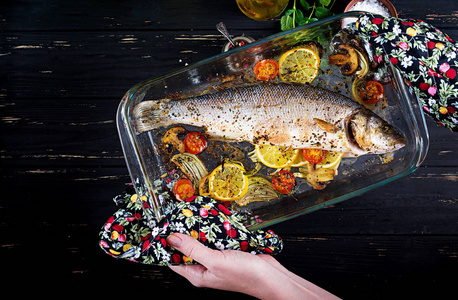 在烤盘中烤海鲈鱼，用香料和蔬菜握在手中。 饮食菜单。 适当的营养。 顶部视图
