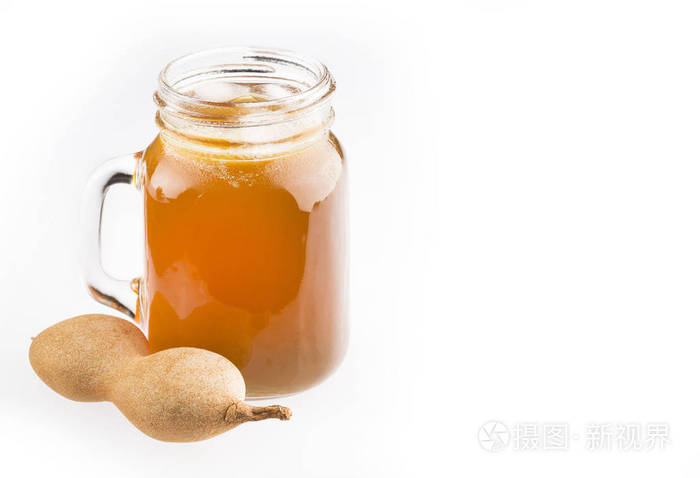 一杯中的罗望子汁被新鲜成熟的罗望子包围