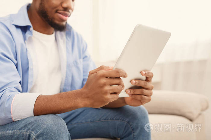 非裔美国人在室内平板电脑上看电影