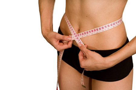 女孩测量她的腰部。 减肥和饮食的概念。 健康的生活方式