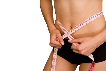 女孩测量她的腰部。 减肥和饮食的概念。 健康的生活方式