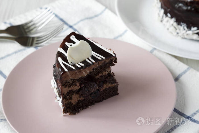 一块自制的巧克力樱桃蛋糕在粉红色的盘子侧面