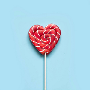 s card. Lollipops candy as heart on blue background. Funny conce
