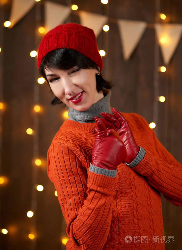 美丽的女人戴着红色手套在深色的木制背景圣诞灯和国旗上摆着节日的