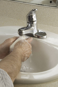在卫生间洗手池里洗手的人