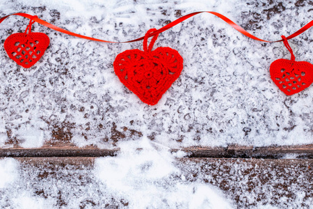 雪上带着丝带的红心。情人节背景