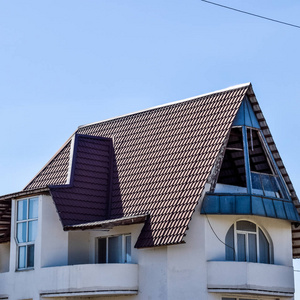 用钢板制成的屋顶隔开的房子。屋顶金属片。现代类型的屋面材料..