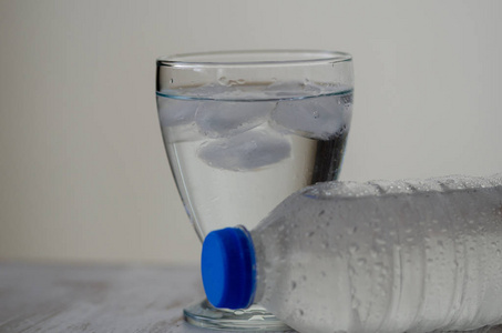 塑料瓶和带冰水的玻璃