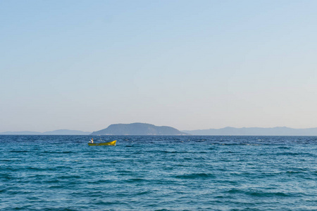 黄色的小摩托艇，一个人在公海上航行。