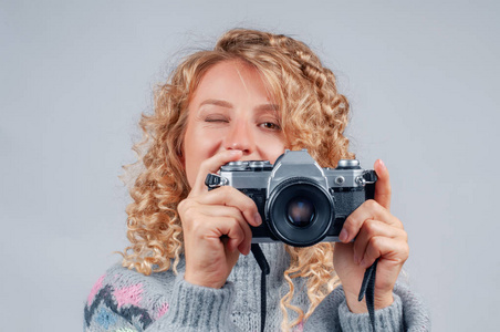 幸福的女人在白色背景上用照相机拍照