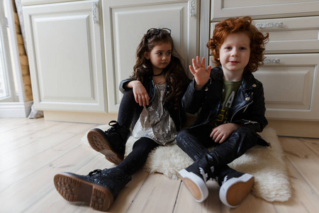 男孩和女孩的朋友坐在地板上玩。