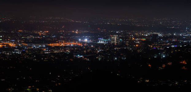 美丽的超广角夜间鸟瞰洛杉矶加利福尼亚美国市中心地区和山脉，天空充满星星和银河从格里菲斯公园天文台看到。