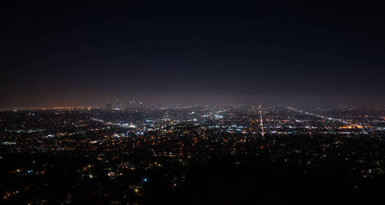 美丽的超广角夜间鸟瞰洛杉矶加利福尼亚美国市中心地区和山脉，天空充满星星和银河从格里菲斯公园天文台看到。
