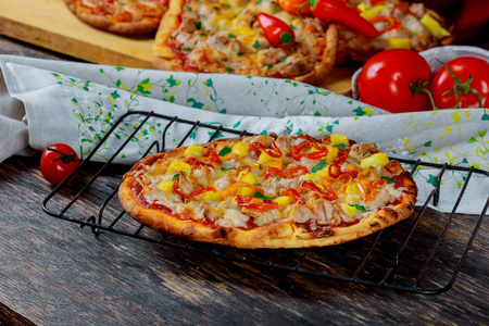 带莫扎拉奶酪的披萨，意大利辣香肠，番茄，意大利披萨，木制桌子背景