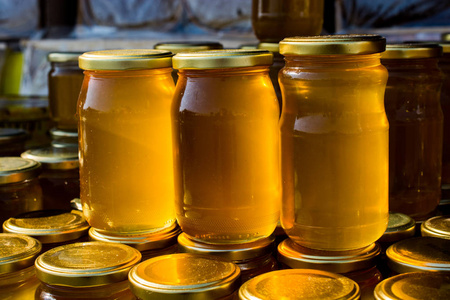 盛满新鲜蜂蜜的玻璃瓶图片