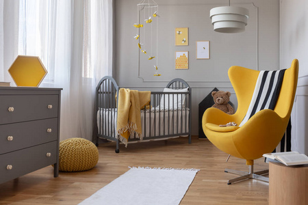 当代婴儿卧室木地板上的白色地毯和黄色帆布照片