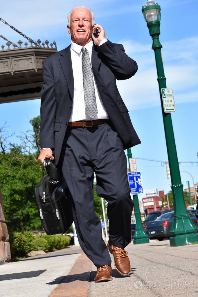 微笑的成年商人走路